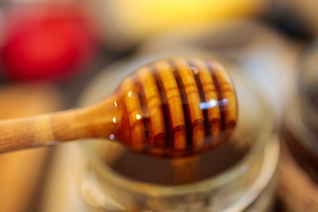 A wooden spoon with a honey on top of it